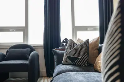a living room with a couch and a chair and windows at Upscale Views 2br Free Parkn, Walk 2 Train, 2bath in East Orange
