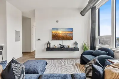 a living room with a couch and a tv on the wall at Upscale Views 2br Free Parkn, Walk 2 Train, 2bath in East Orange