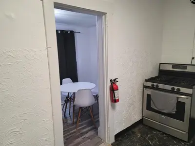 a small kitchen with a table and a stove at Two-Bedroom Home 25 min to NYC Free parking-UNIT-1 in Teaneck