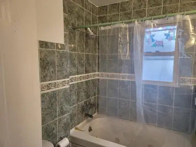 a bathroom with a bath tub and a window at Two-Bedroom Home 25 min to NYC Free parking-UNIT-1 in Teaneck