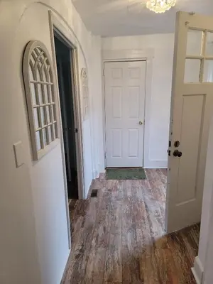 an empty hallway with a white door and wooden floors at Two-Bedroom Home 25 min to NYC Free parking-UNIT-1 in Teaneck