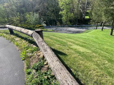 a wooden fence next to a field of grass at Top floor modern country home in Northampton