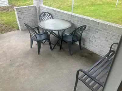 a patio with three chairs and a table and a table and chairs at Top floor modern country home in Northampton