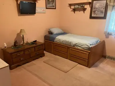 a bedroom with a bed and a dresser and a television at Top floor modern country home in Northampton