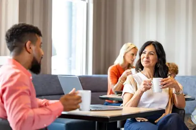 a group of people sitting at a table with cups of coffee at Hyatt Place Secaucus Meadowlands in Secaucus