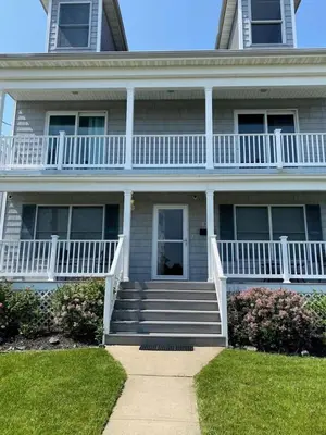 a large house with a porch and stairs on it at Oceanfront Villa - Panoramic NYC Views - Luxury Home in Keansburg