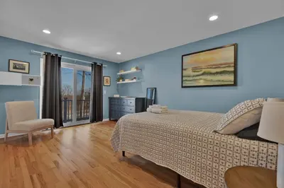a bedroom with blue walls and a bed and a chair at Oceanfront Villa - Panoramic NYC Views - Luxury Home in Keansburg