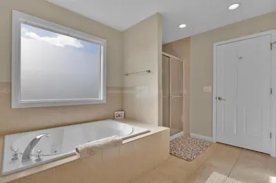 a large bathroom with a tub and a window at Oceanfront Villa - Panoramic NYC Views - Luxury Home in Keansburg