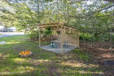a picnic table in a gazebo in a yard at Whimsical Wilderness Lodge in Tobyhanna