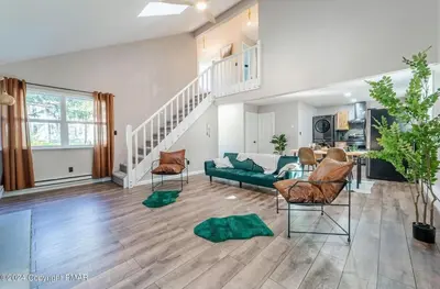 a living room with a green couch and chairs at Whimsical Wilderness Lodge in Tobyhanna