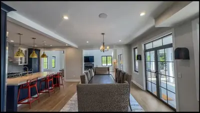 a kitchen and living room with chairs and a bar at Modern Farm Estate Close To Six Flags & Vineyard in Cream Ridge