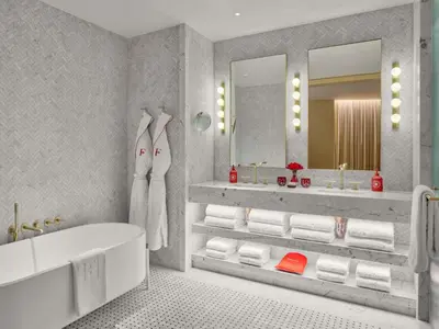 a bathroom with a tub and two sinks and a mirror at Faena New York in New York