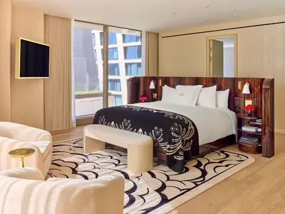 a bedroom with a large bed and a large window at Faena New York in New York