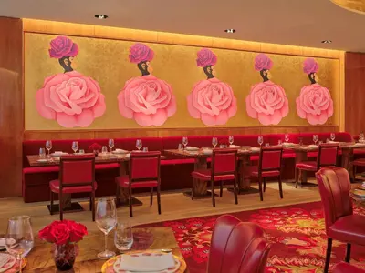 a restaurant with tables with pink roses on the wall at Faena New York in New York