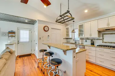 a kitchen with white cabinets and bar stools at Hudson Valley Retreat with Pool Near Greenwood Lake in Monroe