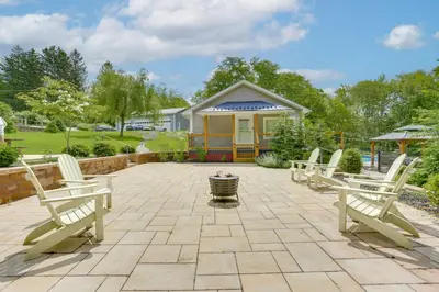 a patio with three white chairs and a house at Hudson Valley Retreat with Pool Near Greenwood Lake in Monroe