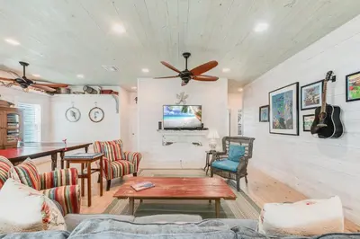 a living room with a ceiling fan and a table at Caney Creek Beach Club - Pet Friendly Golf Cart Included in Philadelphia