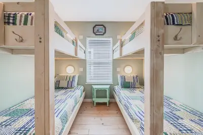 two bunk beds in a room with a window at Caney Creek Beach Club - Pet Friendly Golf Cart Included in Philadelphia