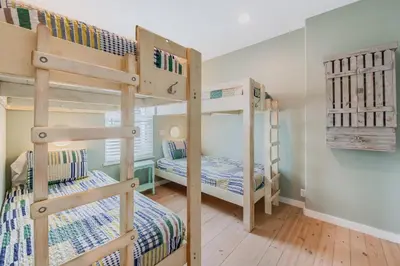 two bunk beds in a room with wooden floors at Caney Creek Beach Club - Pet Friendly Golf Cart Included in Philadelphia