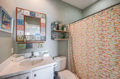 a bathroom with a toilet and a shower curtain at Caney Creek Beach Club - Pet Friendly Golf Cart Included in Philadelphia