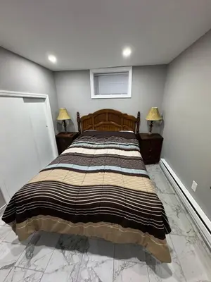 a bedroom with a large bed with two lamps at 2-Bedroom Sleeps 6 Stay Near EWR & American Dream in Newark