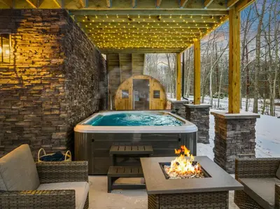 a hot tub in a patio with a fireplace at Luxury Getaway with Nature and Comfort in Albrightsville