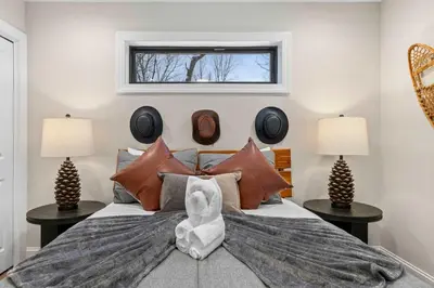 a bedroom with a large bed with two tables at Luxury Getaway with Nature and Comfort in Albrightsville