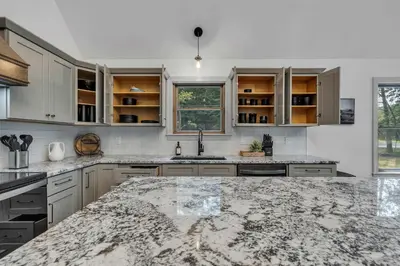 a kitchen with white cabinets and a marble counter top at Luxury Hot Tub Game Room and More in Albrightsville