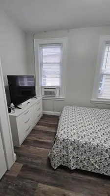 a bedroom with a bed and a flat screen tv at Serenity Haven in Irvington