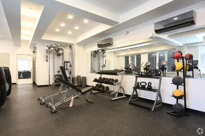 a gym with treadmills and machines in a room at Skyline Studio - Modern Comfort Pool Access in Philadelphia