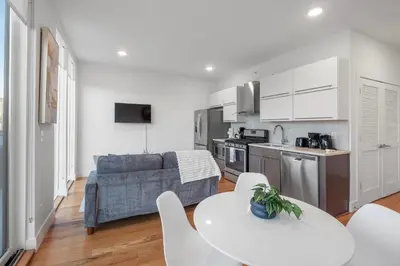 a kitchen and living room with a couch and a table at Luxury 1BR Loft - Skyline Views Pool Access in Philadelphia