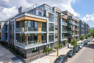 an apartment building on a street with parked cars at Luxury 1BR Loft - Skyline Views Pool Access in Philadelphia