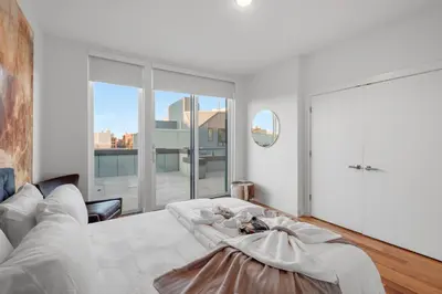 a living room with a white bed and a large window at Luxury 1BR Loft - Skyline Views Pool Access in Philadelphia
