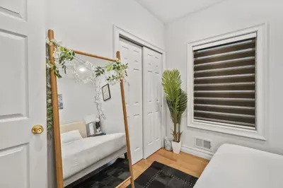 a white room with a mirror and a window at Skyline Haven Luxe NYC Escape in Jersey City