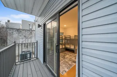 a sliding glass door on a house with a balcony at Skyline Haven Luxe NYC Escape in Jersey City
