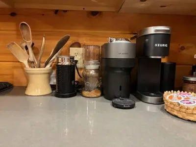 a kitchen counter with a coffee maker and utensils at Waterfront Secluded Log Cabin in Beach Lake