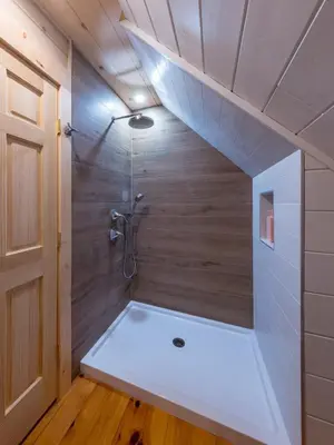 a small bathroom with a shower in a room at Waterfront Secluded Log Cabin in Beach Lake