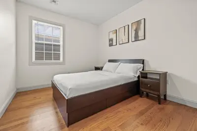 a white bedroom with a bed and a window at HUGE Cozy Jersey City Oasis with Double Balcony - 20 mins to NYC in Jersey City