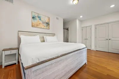 a bedroom with a large white bed in a room at HUGE Cozy Jersey City Oasis with Double Balcony - 20 mins to NYC in Jersey City