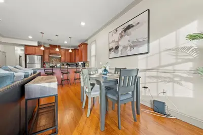 a kitchen and living room with a table and chairs at HUGE Cozy Jersey City Oasis with Double Balcony - 20 mins to NYC in Jersey City