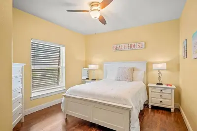 a bedroom with a bed and a ceiling fan at Casa Del Mar - GOLF CART INCLUDED in Philadelphia