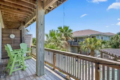 a deck with a green chair and a table at Casa Del Mar - GOLF CART INCLUDED in Philadelphia