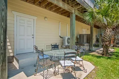 a patio with a table and chairs and a kitchen at Casa Del Mar - GOLF CART INCLUDED in Philadelphia