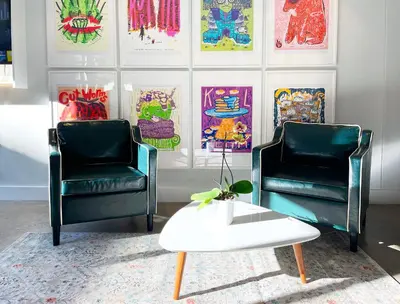 two chairs and a coffee table in a room with paintings at Gallery Suite in Art Tower in Philadelphia