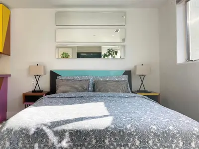 a bedroom with a bed and two lamps and a window at Gallery Suite in Art Tower in Philadelphia