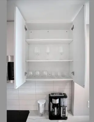 a kitchen with white cabinets and a coffee maker at Midtown View - Minutes to City in Hoboken