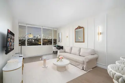 a living room with a couch and a table at Midtown View - Minutes to City in Hoboken