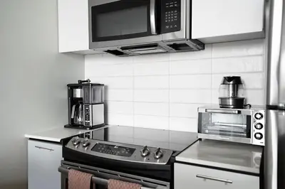 a kitchen with a stove and a microwave at Exclusive 1BR Apt with NYC View in Hoboken