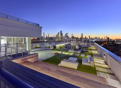 a rooftop deck with chairs and a view of the city at Exclusive 1BR Apt with NYC View in Hoboken
