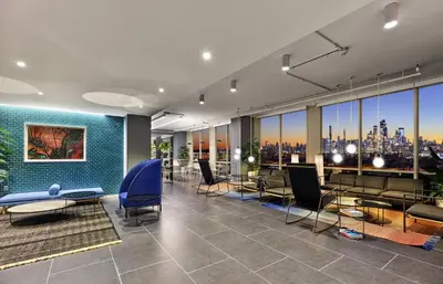 a lobby with tables and chairs and a view of the city at Exclusive 1BR Apt with NYC View in Hoboken